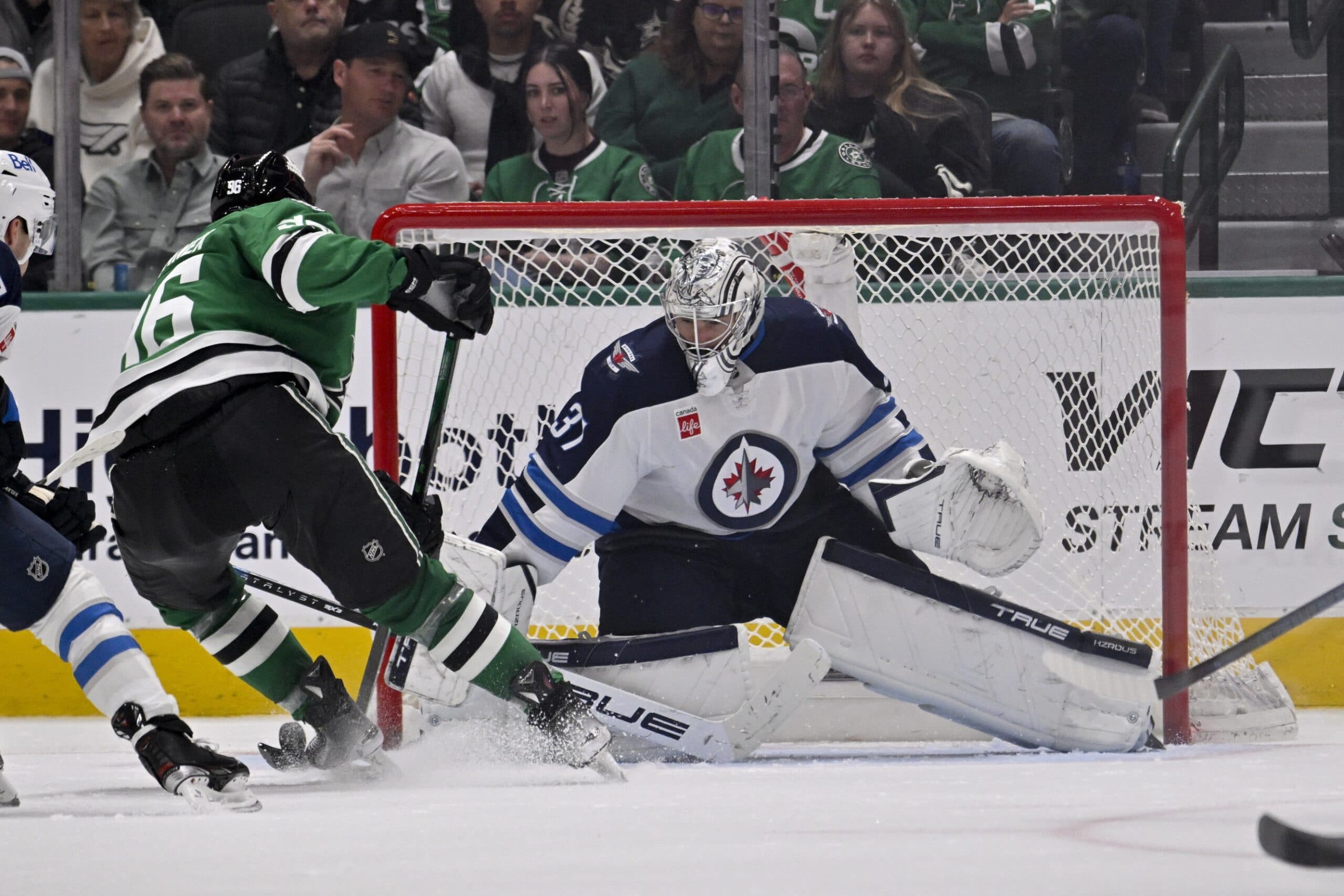 Winnipeg Jets goaltender Connor Hellebuyck (37) stops a breakaway shot by Dallas Stars right wing Mikko Rantanen (96) during the third period at the American Airlines Center.