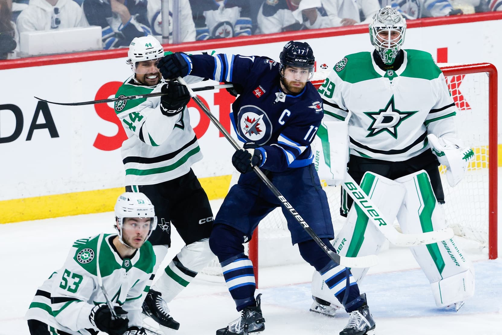 Dallas Stars defenseman Cody Ceci (44) jostles for position with Winnipeg Jets forward Adam Lowry (17) in front of Dallas Stars goalie Jake Oettinger (29) during the third period in game one of the second round of the 2025 Stanley Cup Playoffs at Canada Life Centre