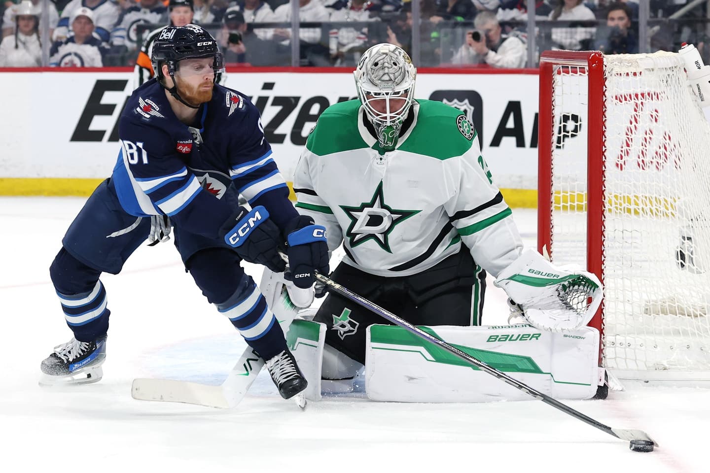 Winnipeg Jets left wing Kyle Connor (81) stretches for the puck in front of Dallas Stars goaltender Jake Oettinger (29) in the second period in game two of the second round of the 2025 Stanley Cup Playoffs at Canada Life Centre