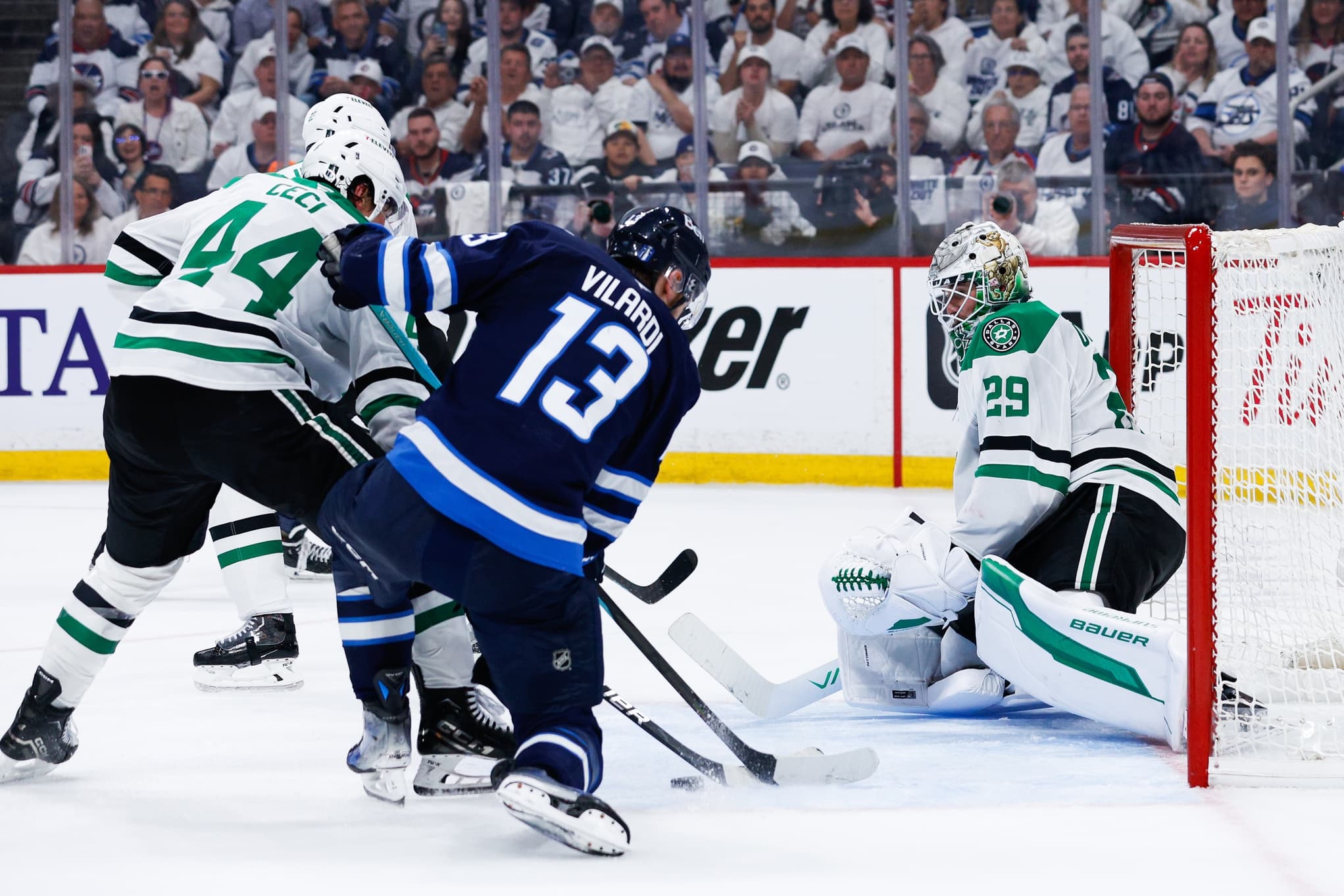 Winnipeg Jets forward Gabriel Vilardi (13) and Dallas Stars defenseman Cody Ceci (44) contest for the puck in front of Dallas Stars goalie Jake Oettinger (29) during the second period in game five of the second round of the 2025 Stanley Cup Playoffs at Canada Life Centre.
